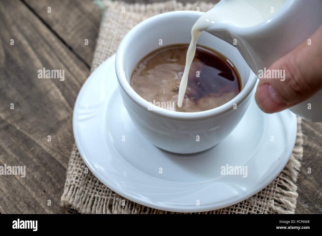 Verser le lait dans une tasse de café, Close up Banque D'Images