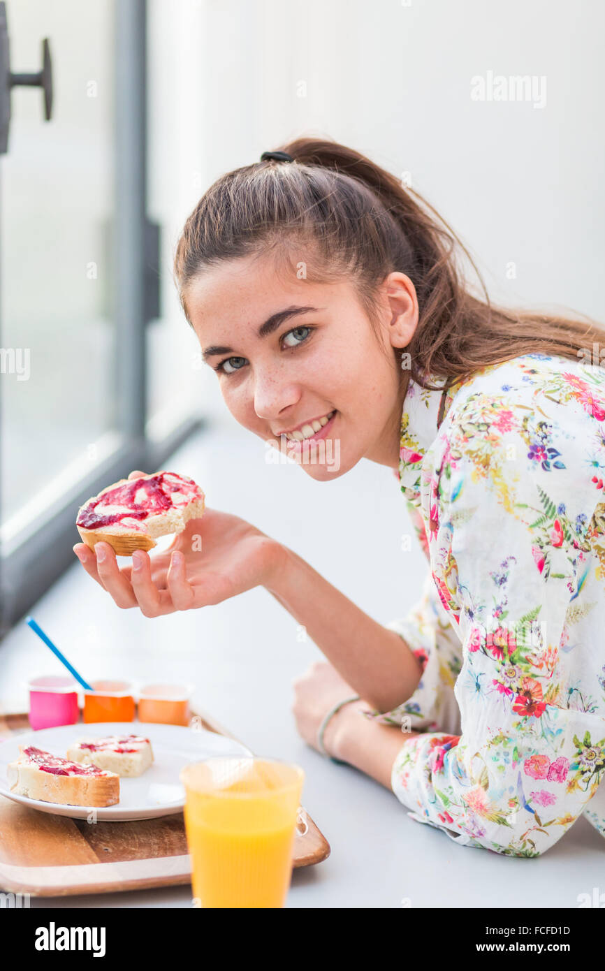 Femme mangeant un sandwich confiture. Banque D'Images