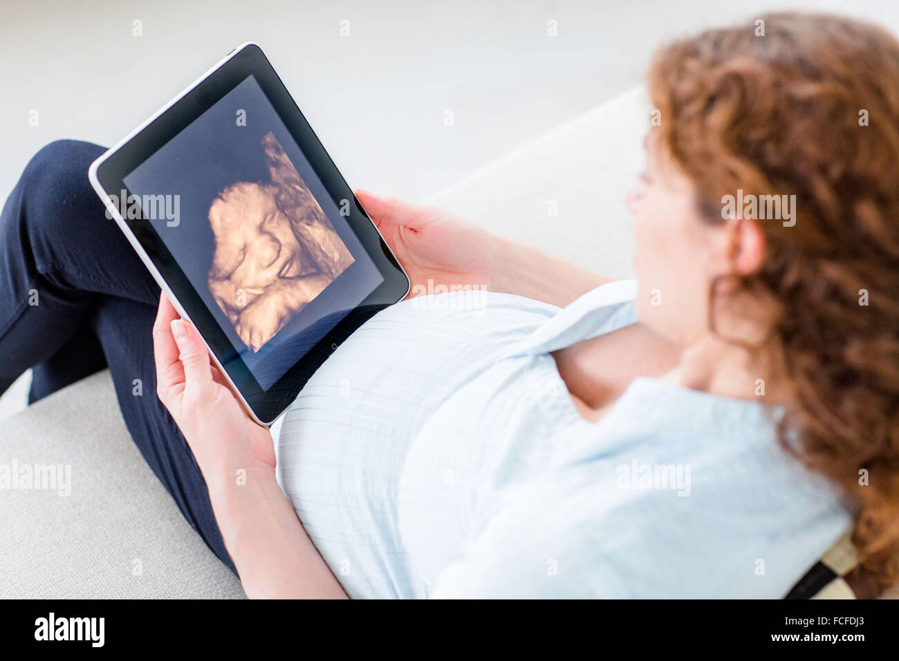 Woman looking at baby scan sur une tablette numérique. Banque D'Images