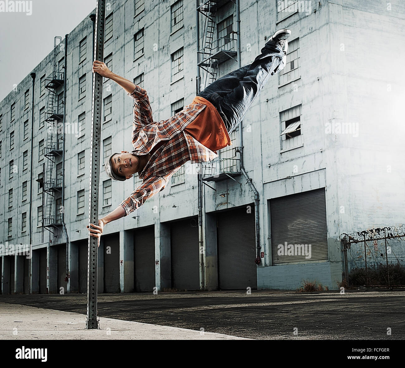 Un jeune homme breakdancing, sautant en l'air, et les étirements. Banque D'Images
