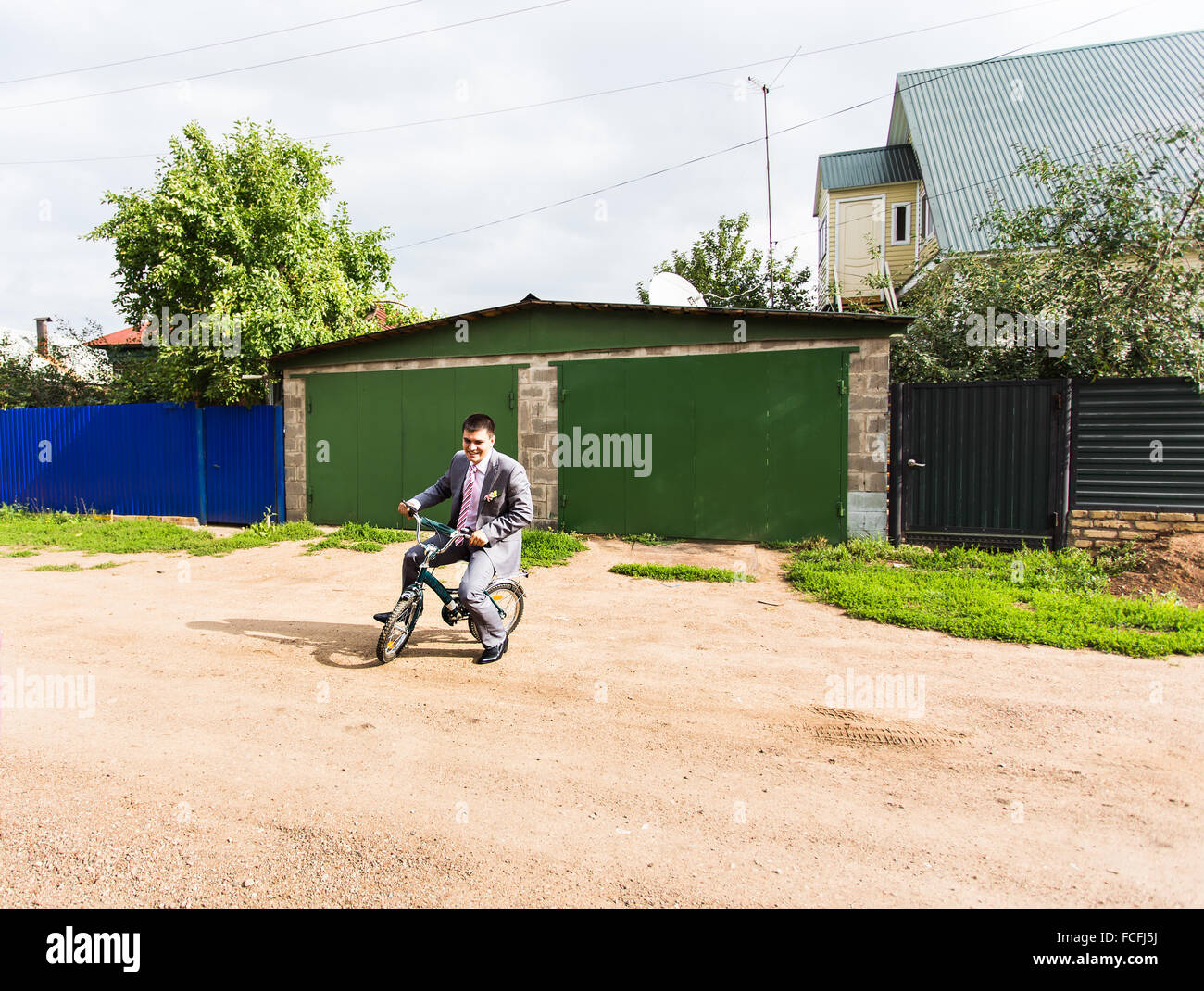 Businessman riding bicyclette d'enfant Banque D'Images