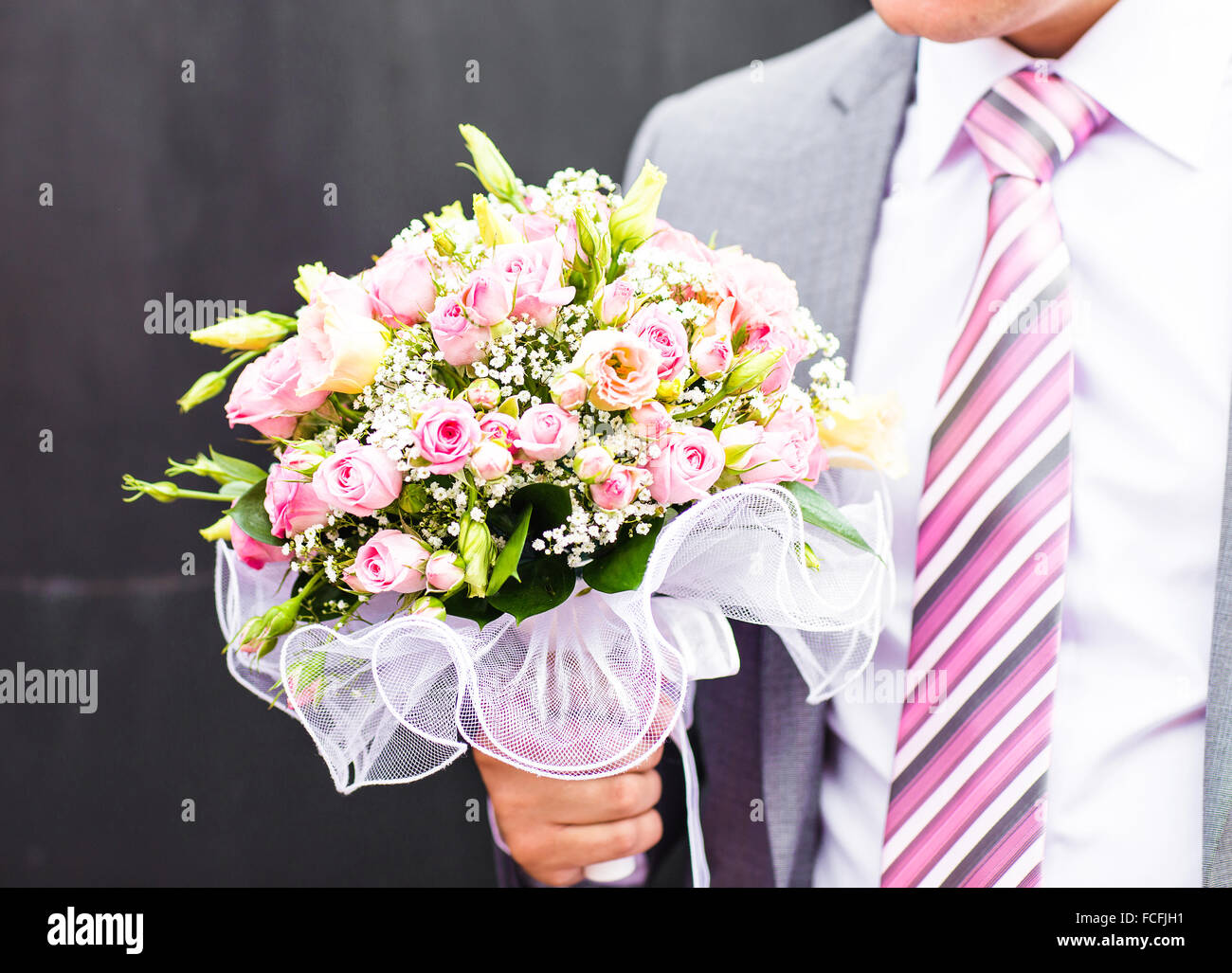 Groom holding bouquet de mariage Banque D'Images