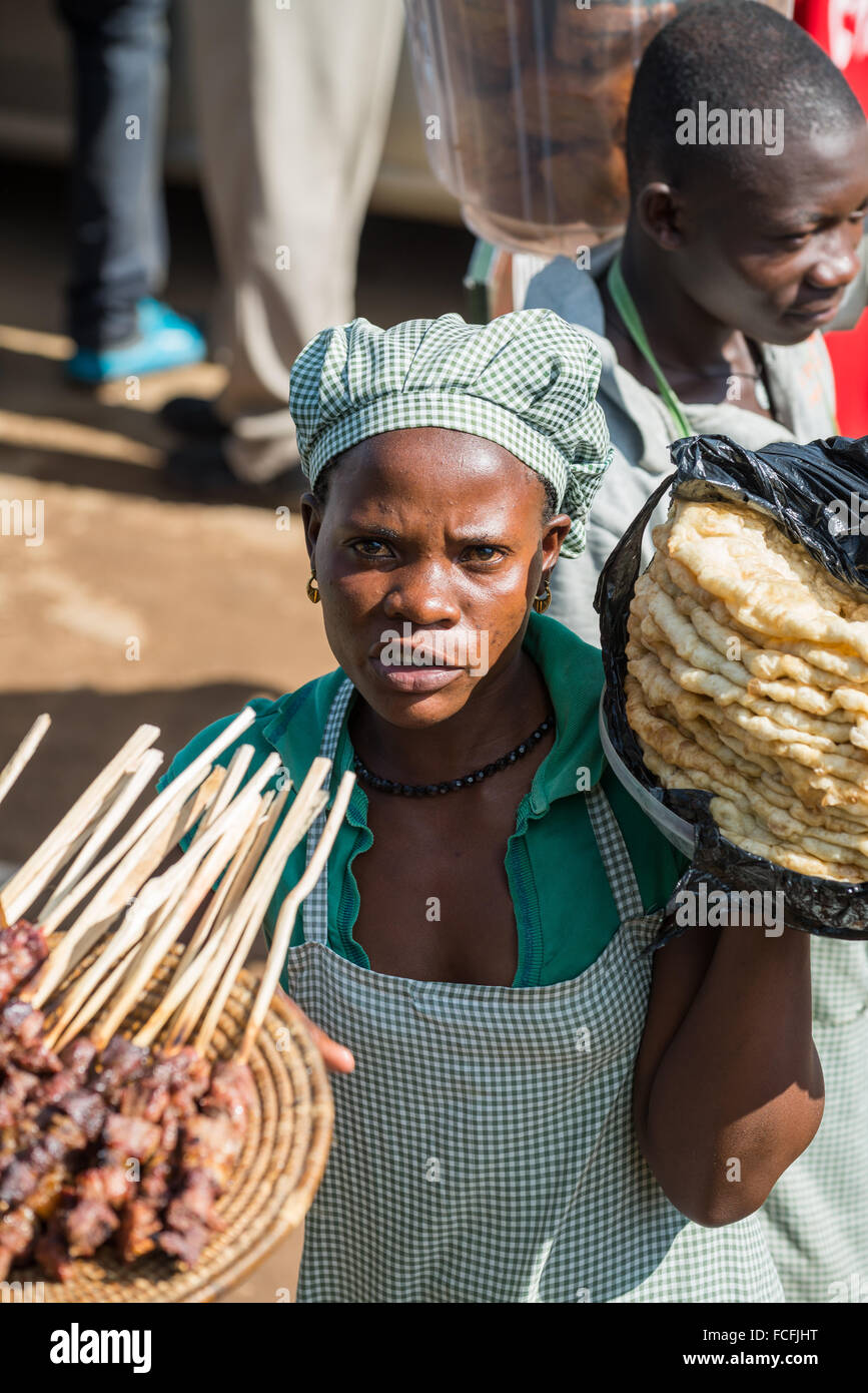 Les vendeurs de rue vendent des marchandises pour les gens dans les bus locaux en passant par les villages sur la route de Kampala, Ouganda, Afrique du Sud Banque D'Images