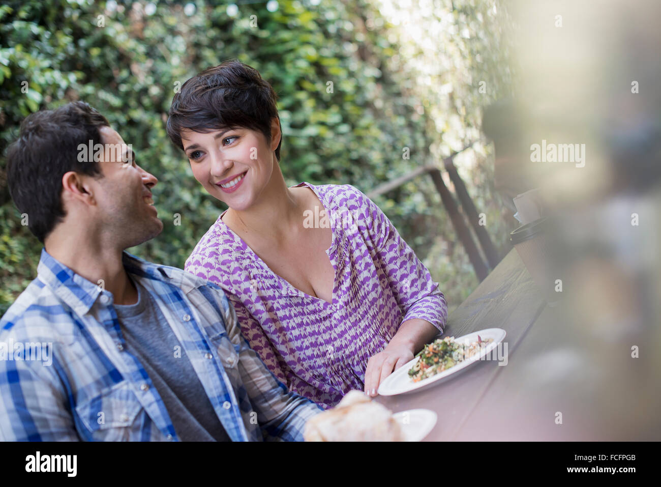 Un couple dans un parc de la ville cafe ayant un repas. Banque D'Images