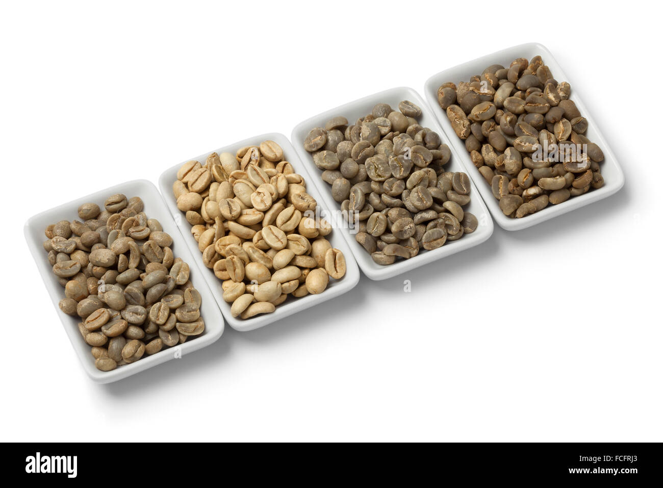 Quatre types de grains de café non torréfié vert sur fond blanc Banque D'Images