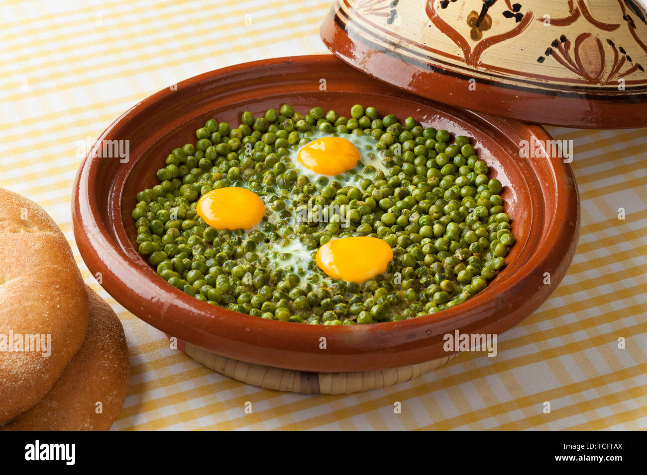 Tajine marocain avec des pois verts et des œufs au plat Banque D'Images