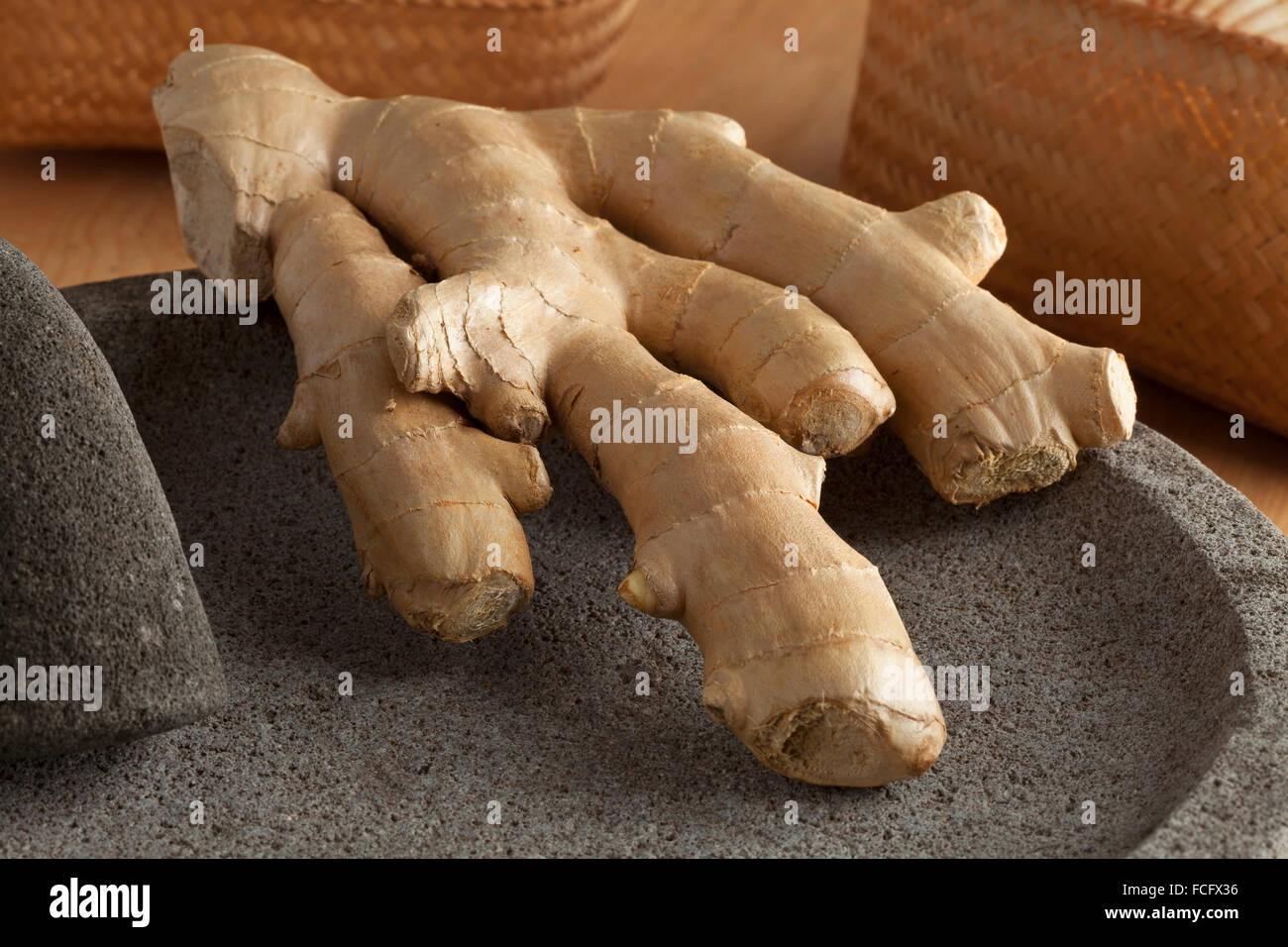 Rhizome de gingembre frais fermer jusqu'à l'aide d'un pilon et mortier Banque D'Images