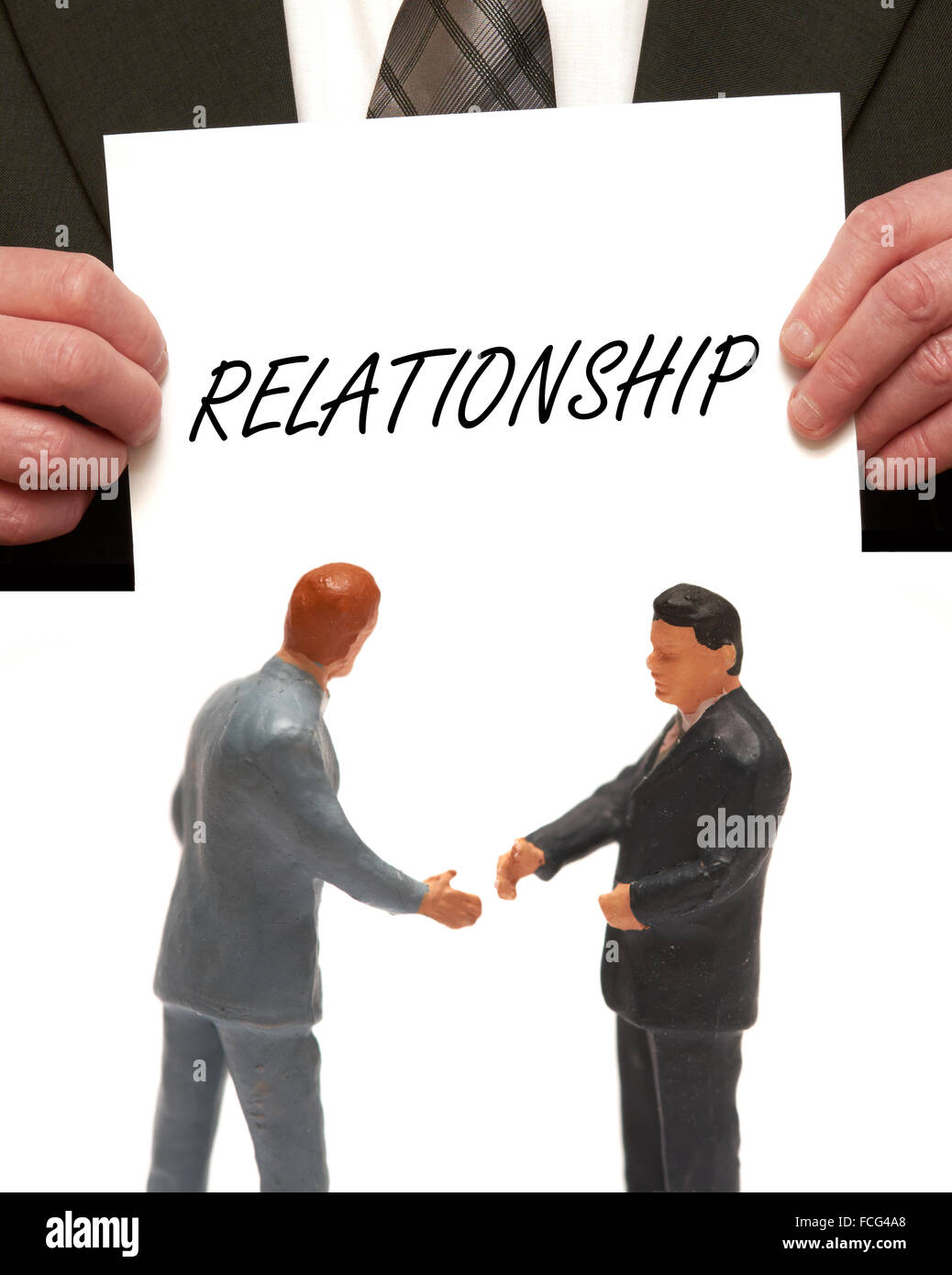 Le concept de relation 2 miniatures en costumes shaking hands Banque D'Images