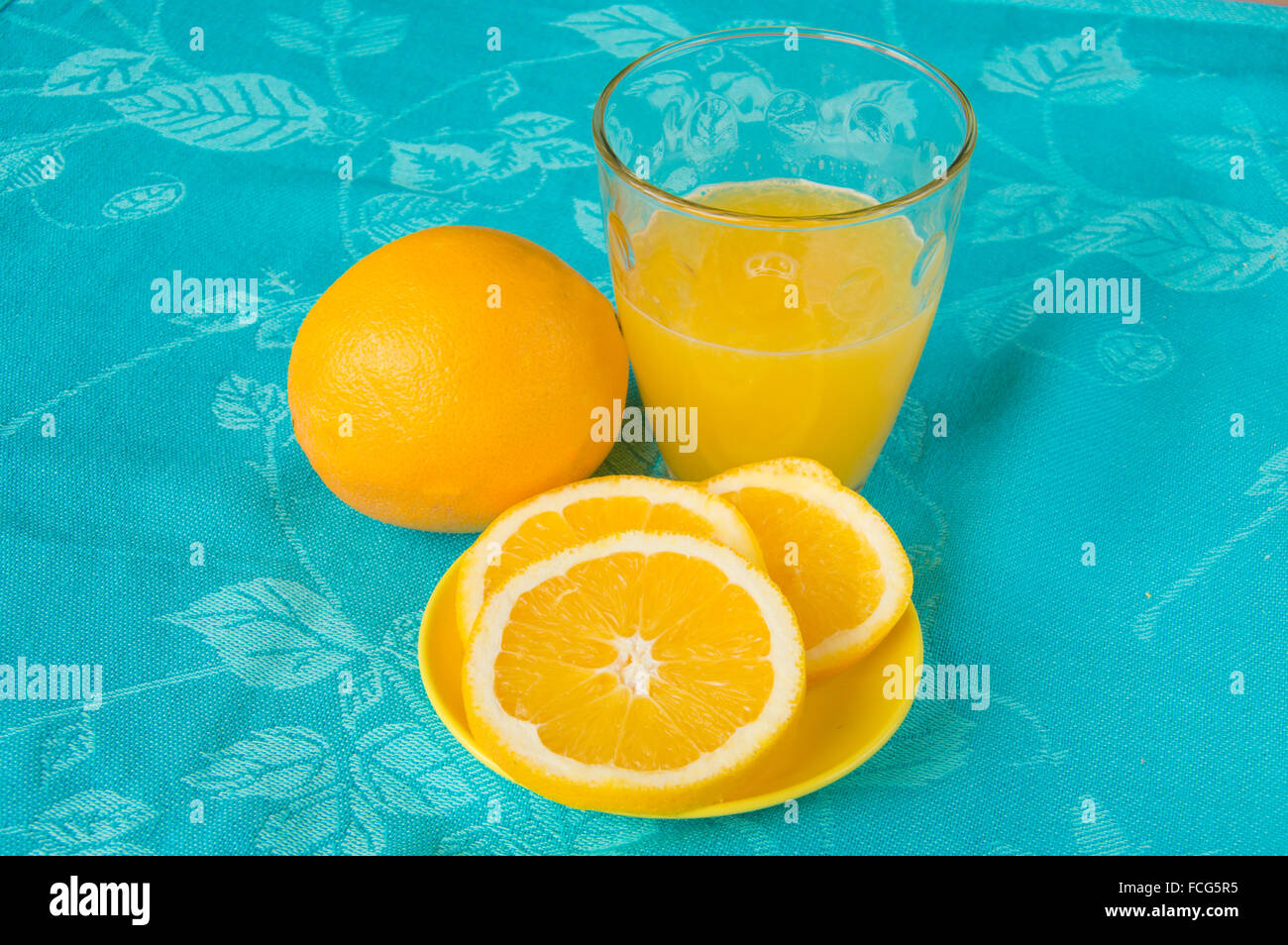 Bon matin avec du jus d'orange sur fond bleu Banque D'Images