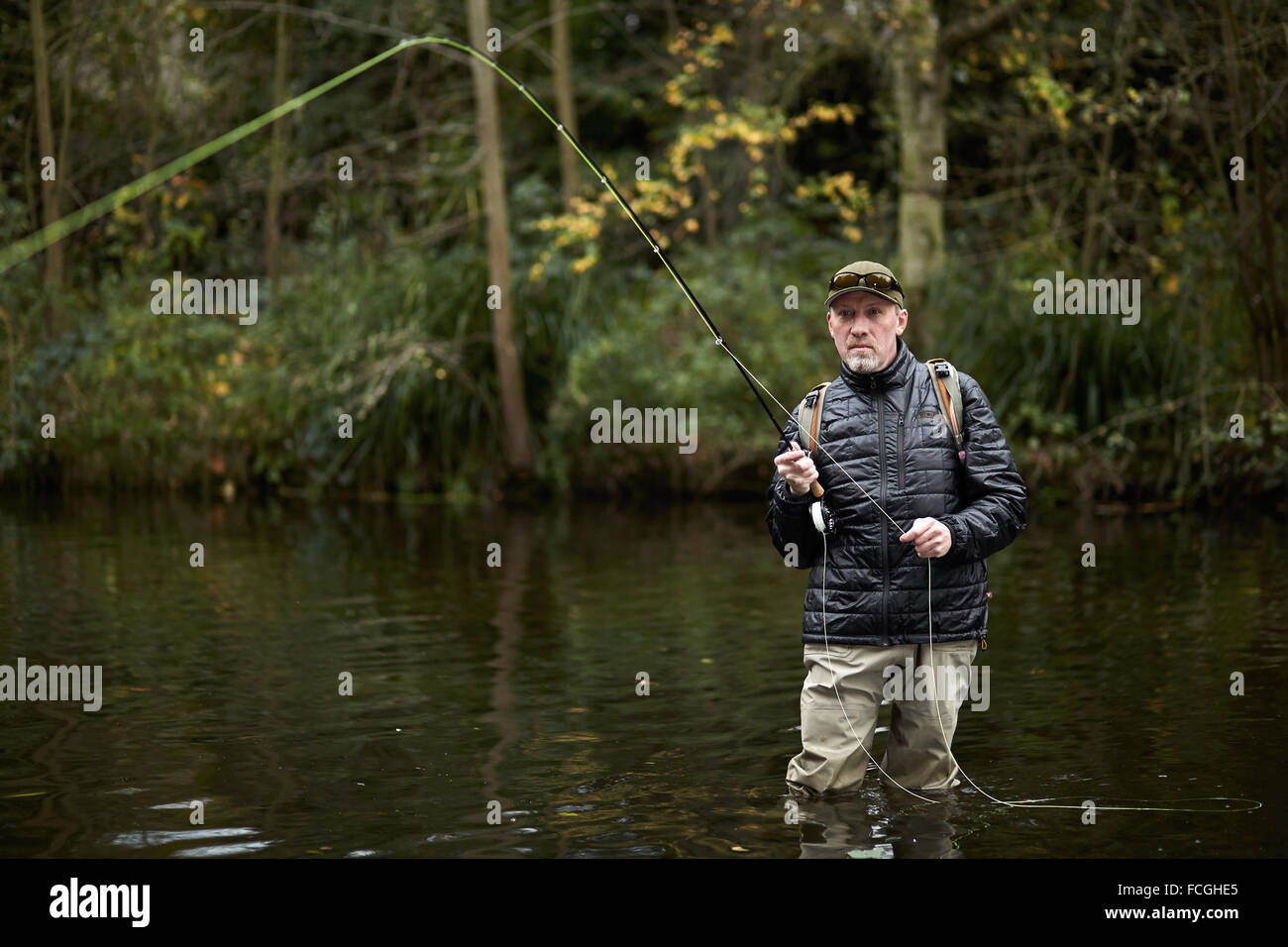 Un homme pêche à la mouche dans une rivière Banque D'Images