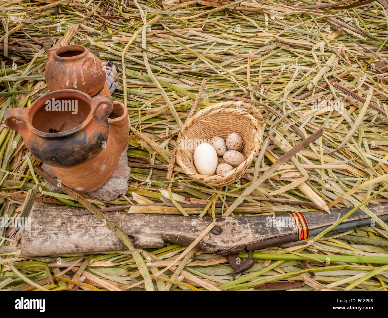 Affichage des oeufs dans le panier, vieux fusil et vide les pots d'argile sur les roseaux sur Île flottante, le Lac Titicaca, au Pérou, en Amérique du Sud. Banque D'Images