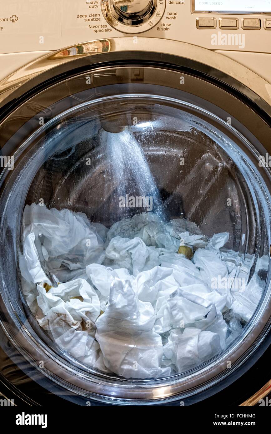 Une charge de laver dans un lave-linge à chargement frontal, la  pulvérisation d'eau de rinçage dans le compartiment Photo Stock - Alamy