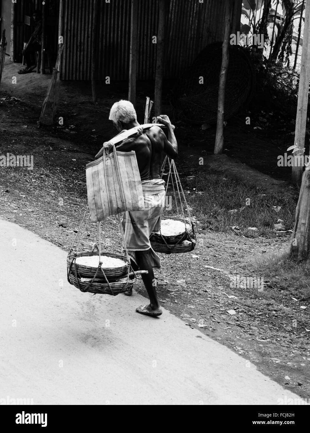 Old man carrying load Banque D'Images