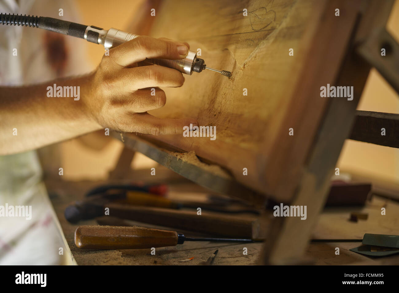 Homme adulte au travail que l'artiste, la ciselure un bas-relief dans son atelier. Il travaille avec un foret à bois Ciseau une peinture. Banque D'Images