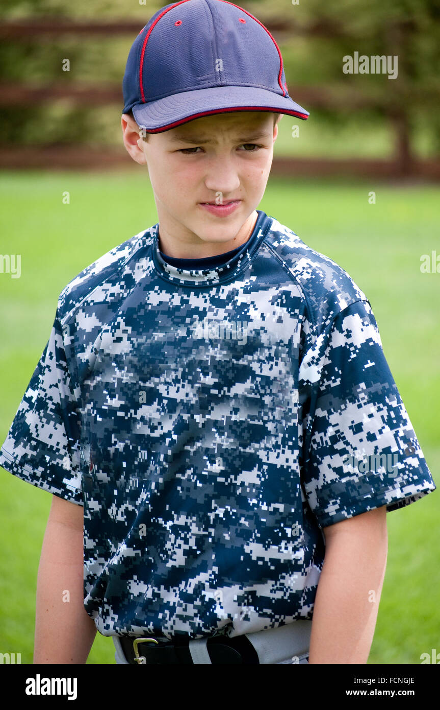 Jeune garçon de baseball à l'extérieur avec l'uniforme de camouflage à la caméra de Banque D'Images