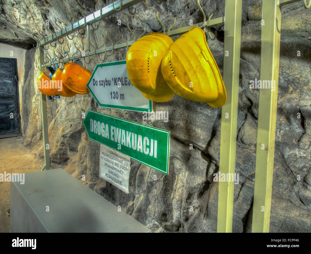 Ruda Slaska, Pologne - 05 novembre 2015 : les casques de protection jaune accroché en face d'une entrée dans un puits de mine de charbon. Banque D'Images