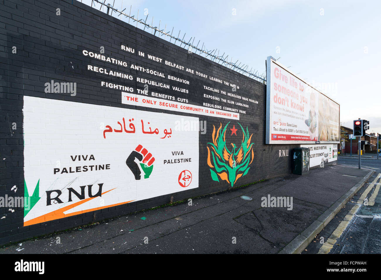 Peinture murale du RNU à Belfast's Falls Road avec la Palestine message de solidarité. Banque D'Images
