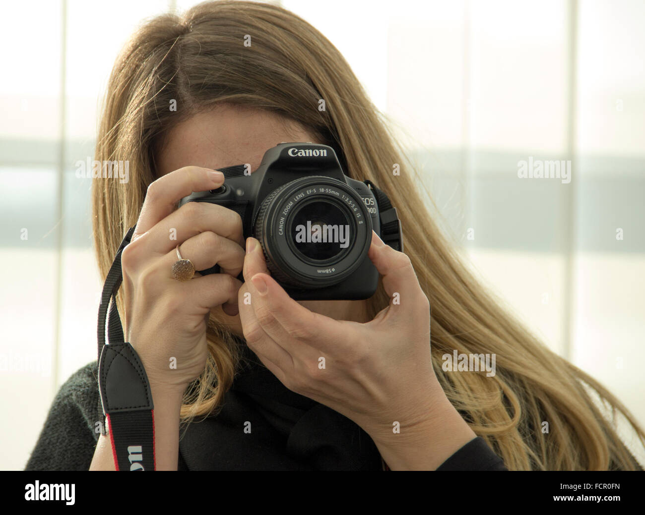 Jeune femme photographe à l'aide d'un appareil photo reflex numérique Canon Banque D'Images