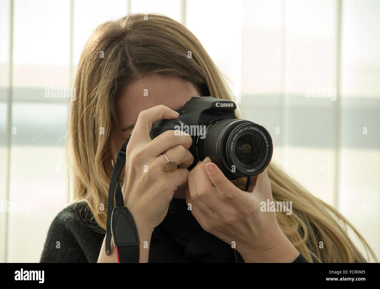 Jeune femme photographe à l'aide d'un appareil photo reflex numérique Canon Banque D'Images