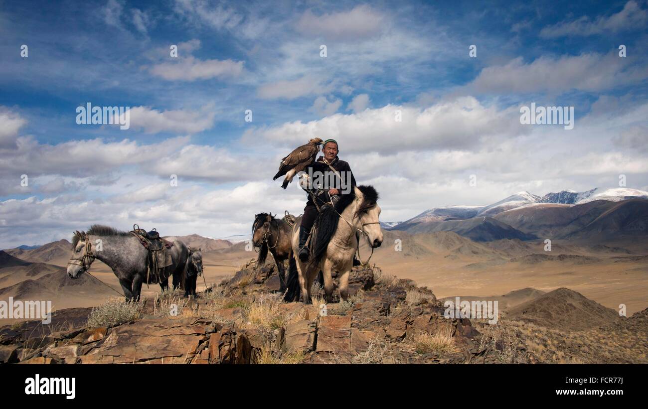 Un Burkitshi hunter posent à cheval au cours de la Mongolian Golden Eagle Festival à Olgii, la Mongolie. Banque D'Images