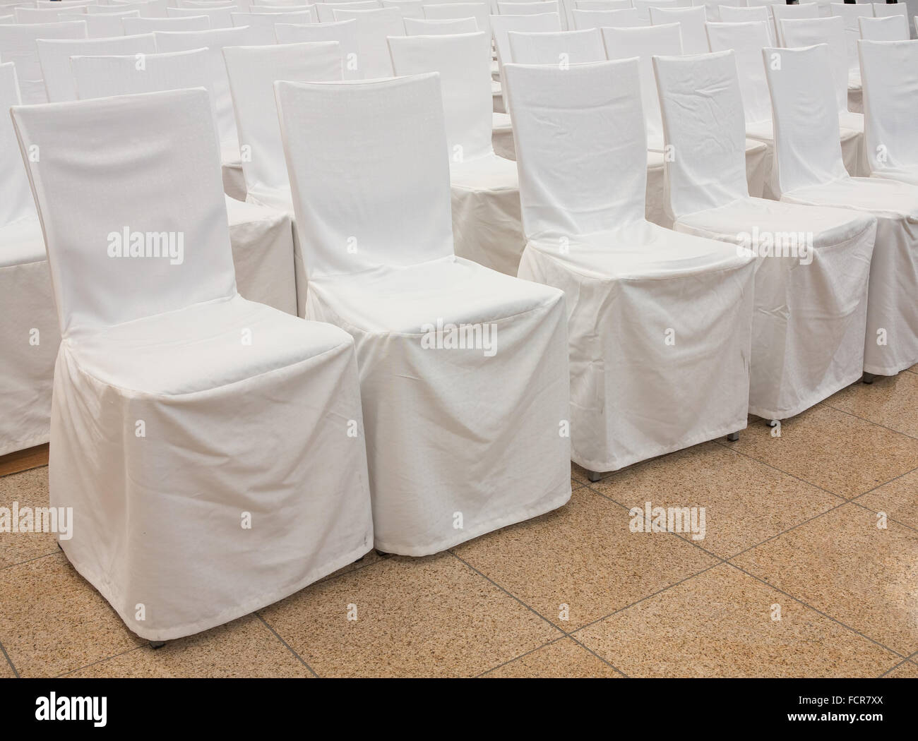 Chaises avec tissu blanc couvre dans une rangée Banque D'Images