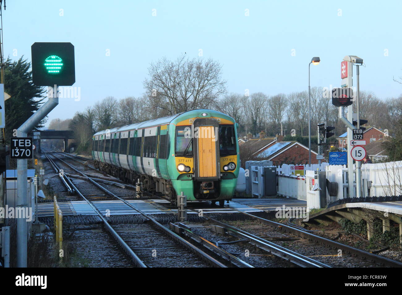 SOUTHERN RAILWAY TRAIN ÉLECTRIQUE AU PASSAGE À NIVEAU DE POLEGATE PRÈS DE LA GARE FERROVIAIRE DANS L'East Sussex Banque D'Images