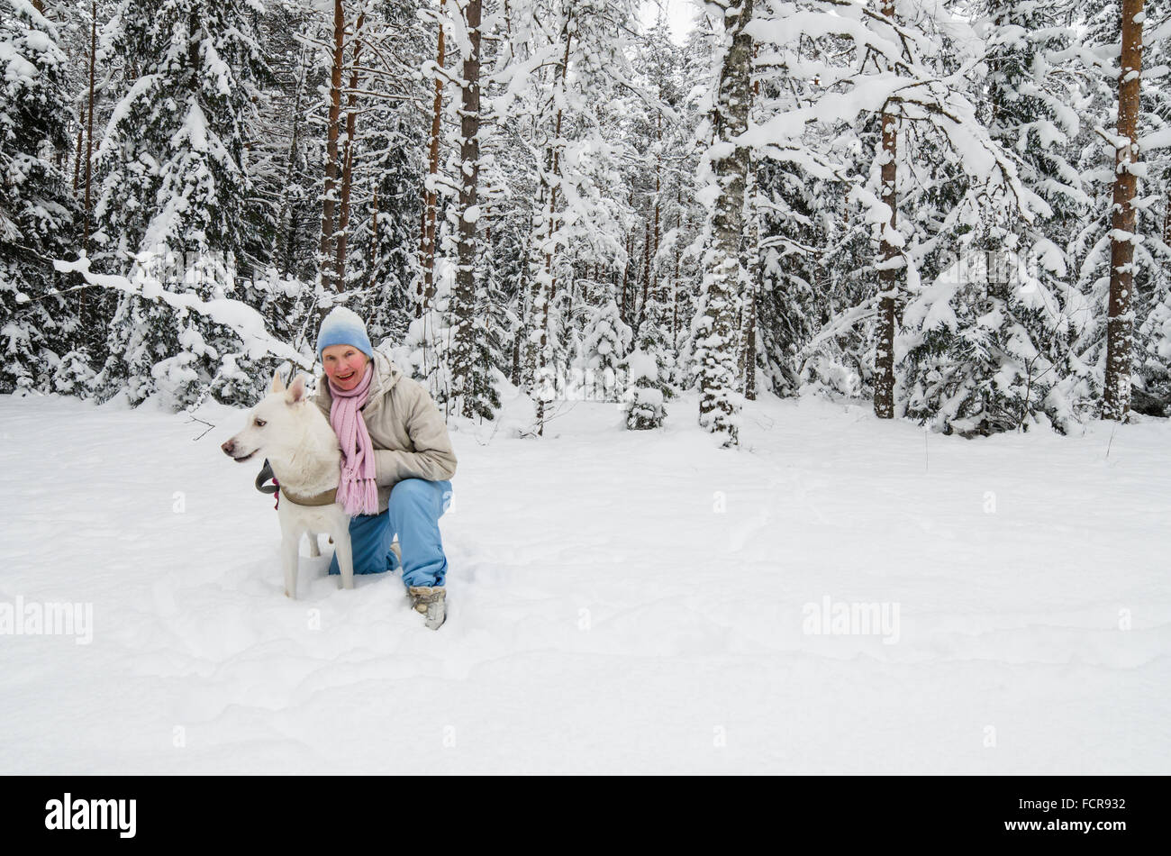 La femme avec un chien en promenade dans un bois d'hiver Banque D'Images