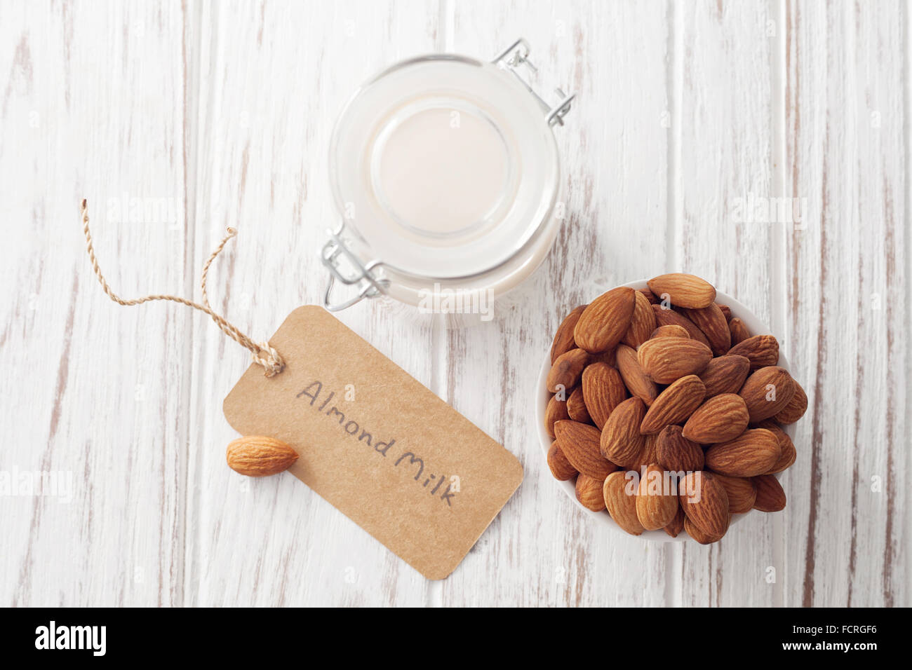 Bio au lait d'amande noix sain végétarien végétalien verre fond blanc bois rustique en teck label vie encore Banque D'Images