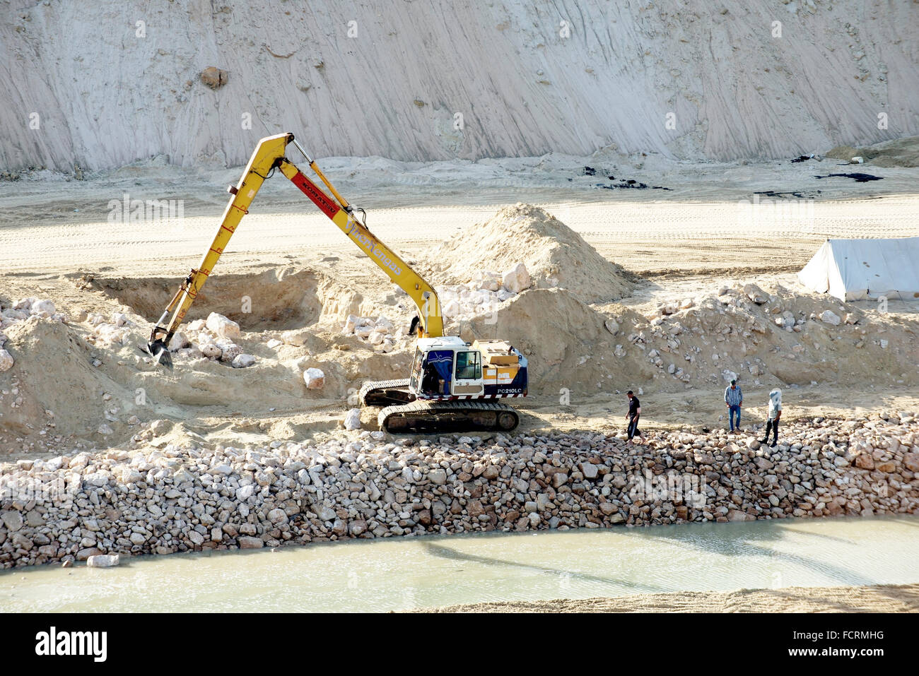 Egyptiens regarder sur le rivage au début d'une construction sur les rives du nouveau canal de Suez. Banque D'Images