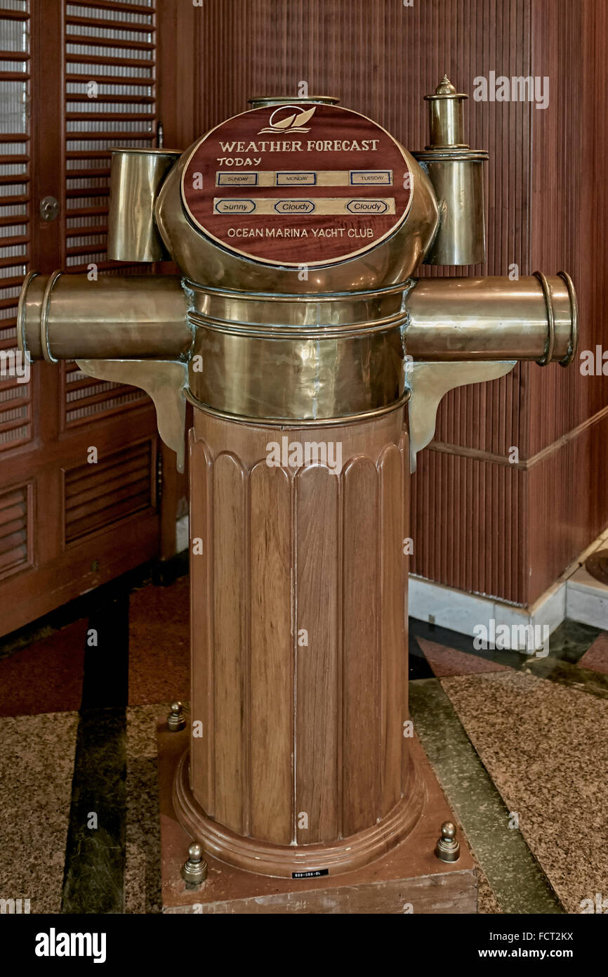 Météo. Support de compas en laiton d'expédition converti en un élément de prévision météo quotidien dans un yacht club local. Banque D'Images