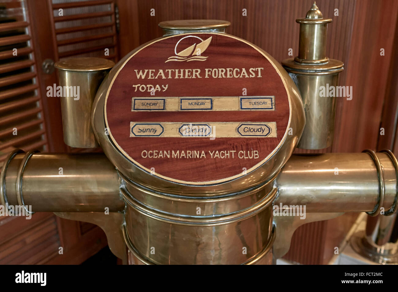 Météo. Support de compas en laiton d'expédition converti en un élément de prévision météo quotidien dans un yacht club local. Banque D'Images