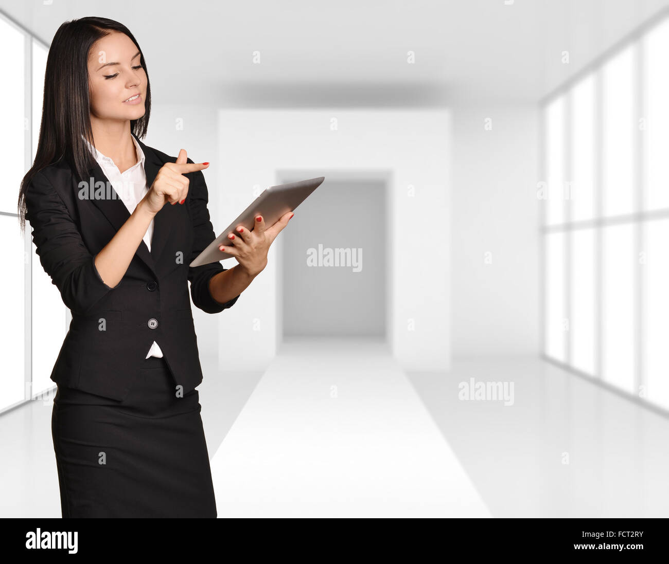 Jeune fille se tient sur le fond de cette chambre lumineuse holding a tablet Banque D'Images