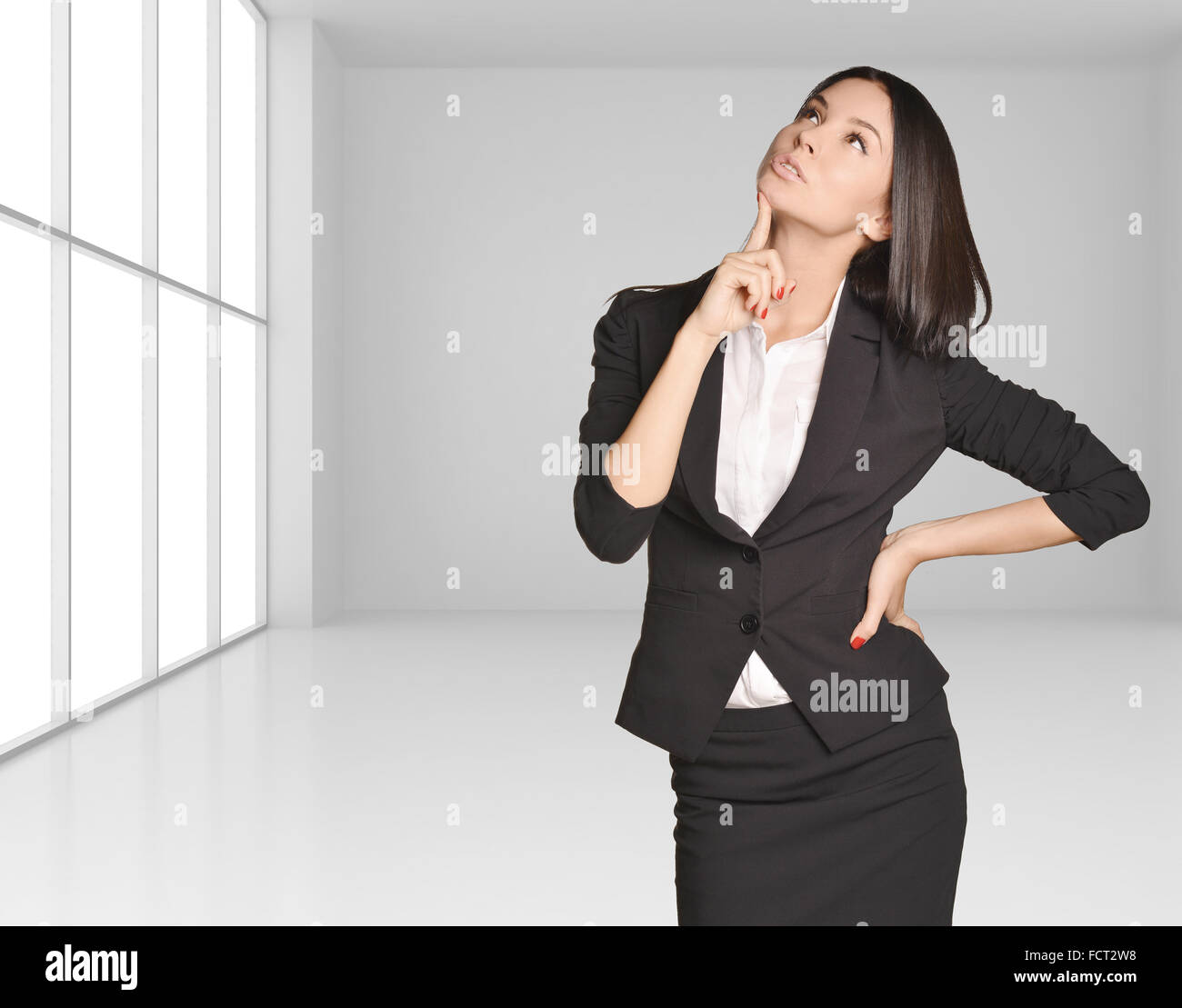 Femme debout sur fond d'intérieur lumineux avec grande fenêtre chambre et la pensée looking up Banque D'Images