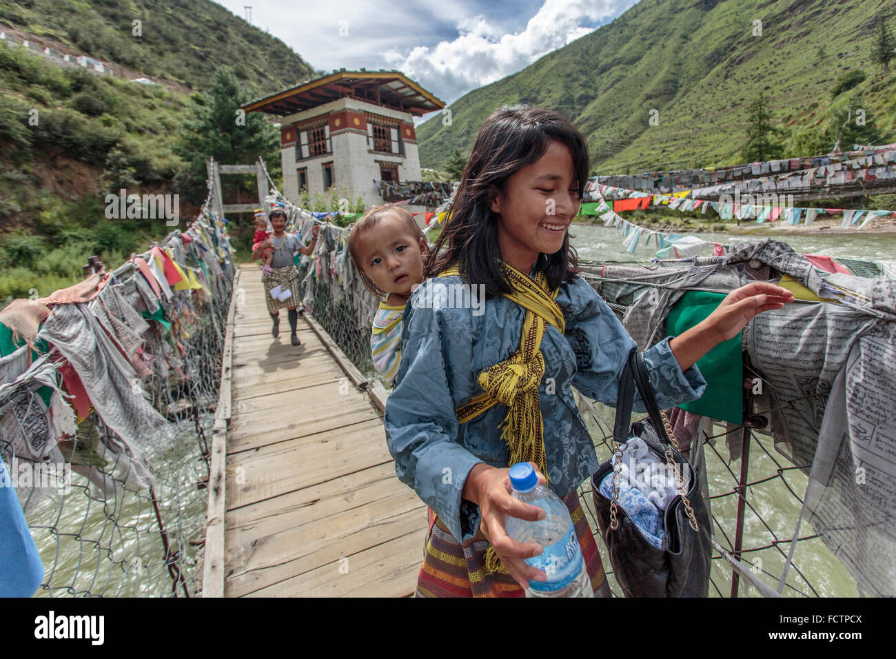 La mère et l'enfant traversant un pont suspendu près de Thimphu, Bhoutan Banque D'Images