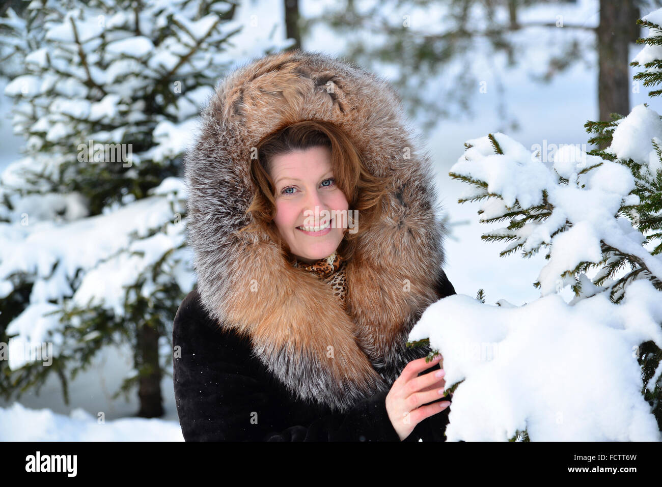 Femme d'âge moyen positif en manteau de fourrure à winter park Banque D'Images