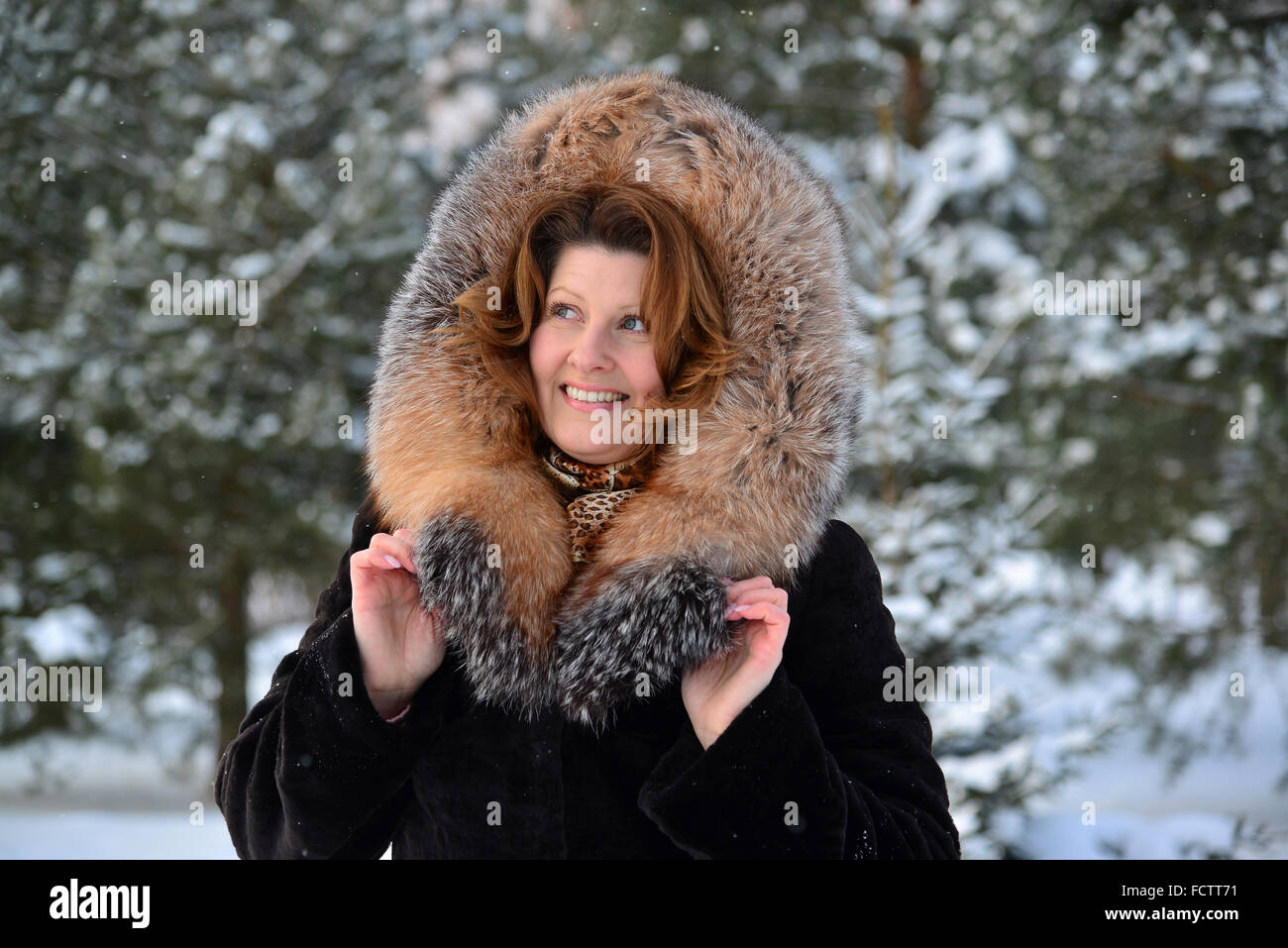 Femme d'âge moyen positif en manteau de fourrure à winter park Banque D'Images