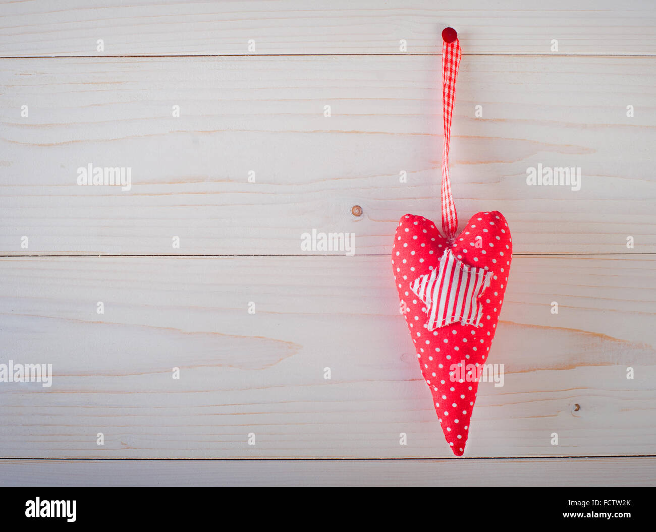 Coeur rouge à pois blancs sur un fond de bois Banque D'Images