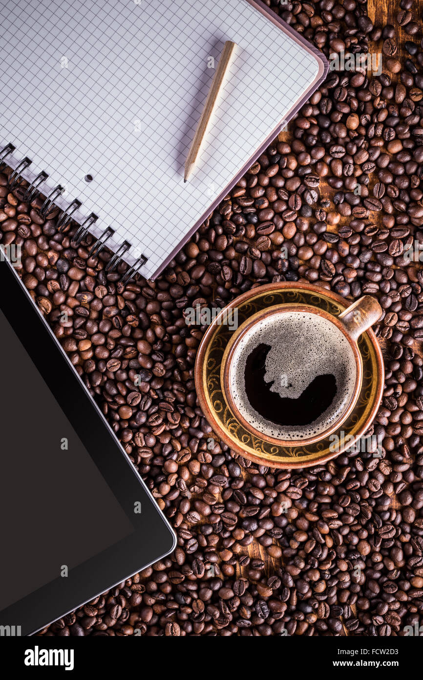 Tablette numérique, papier et sur les grains de café tasse de café contexte Banque D'Images
