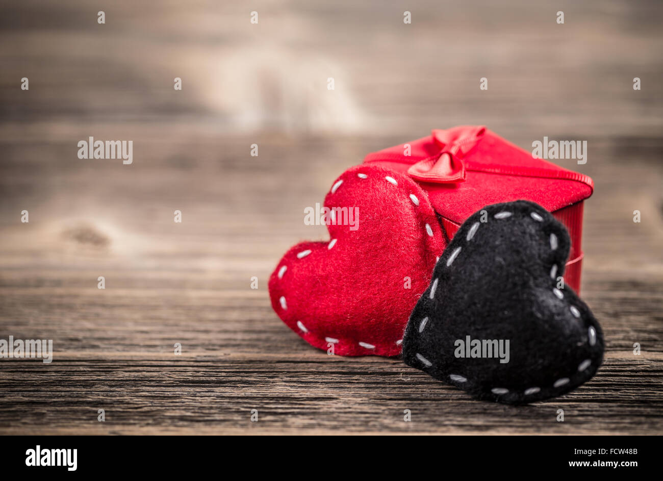 Concept de divorce avec rouge et coeurs de feutre noir sur fond de bois vintage Banque D'Images