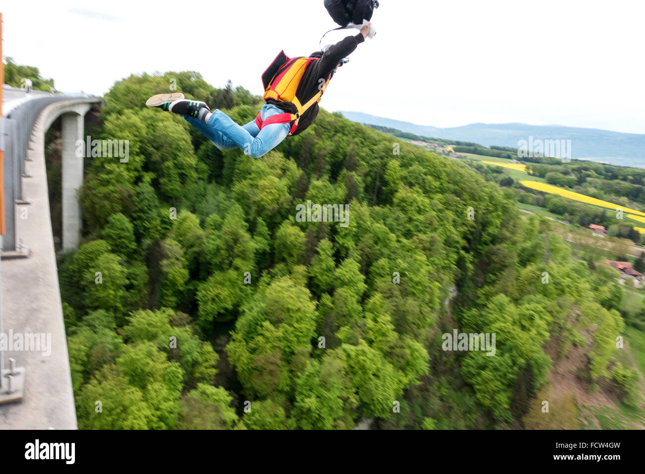 L'homme est sortie d'un pont avec son équipement de base jumping. Avec le pilote-chute dans sa main qu'il force le processus d'ouverture. Banque D'Images
