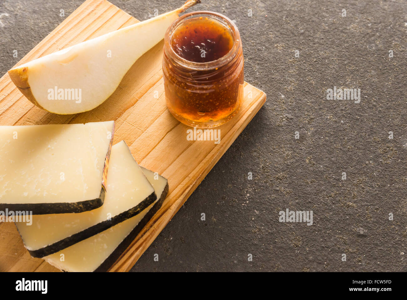 Une composition de tranches de fromage pecorino italien avec de la confiture et les poires sur une planche à découper en bois Banque D'Images