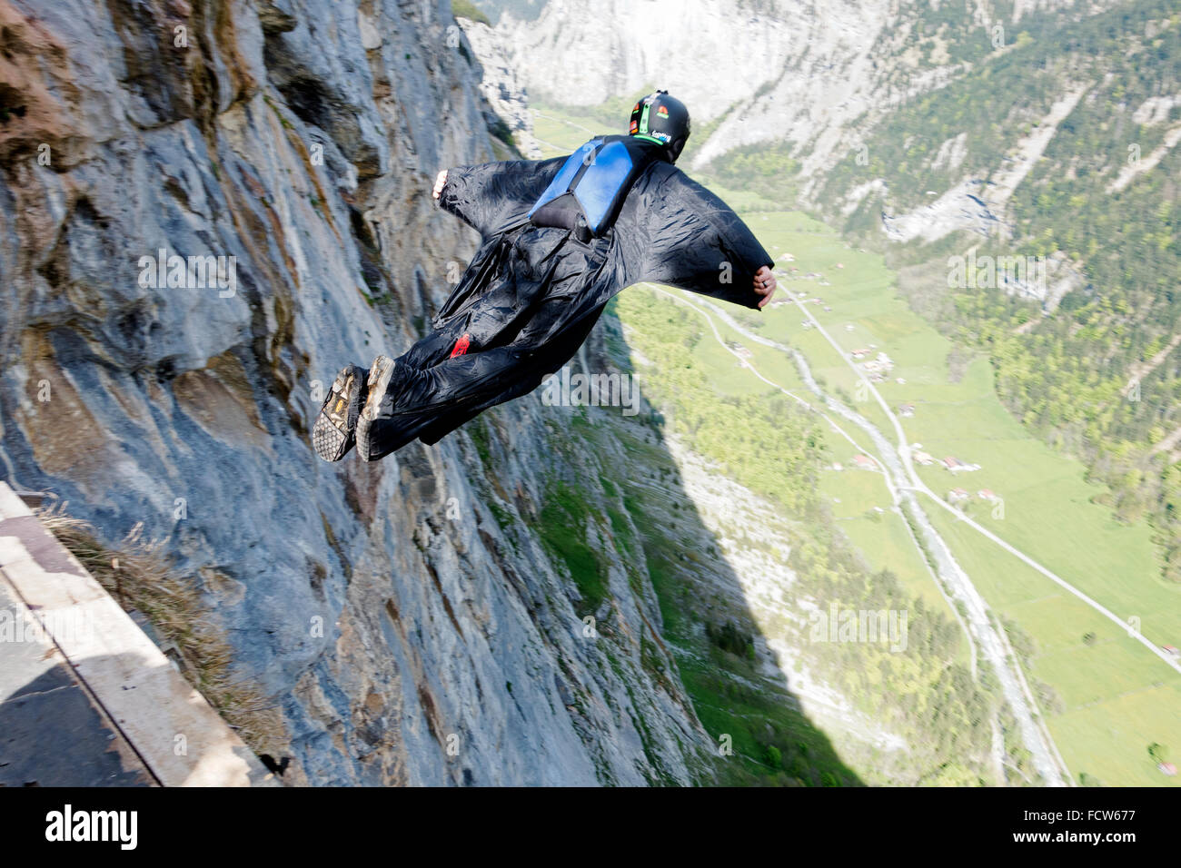 Homme dans un costume Birdman saute d'une falaise. Il est ainsi étirez les ailes et vont monter le long des murs de la montagne. Banque D'Images