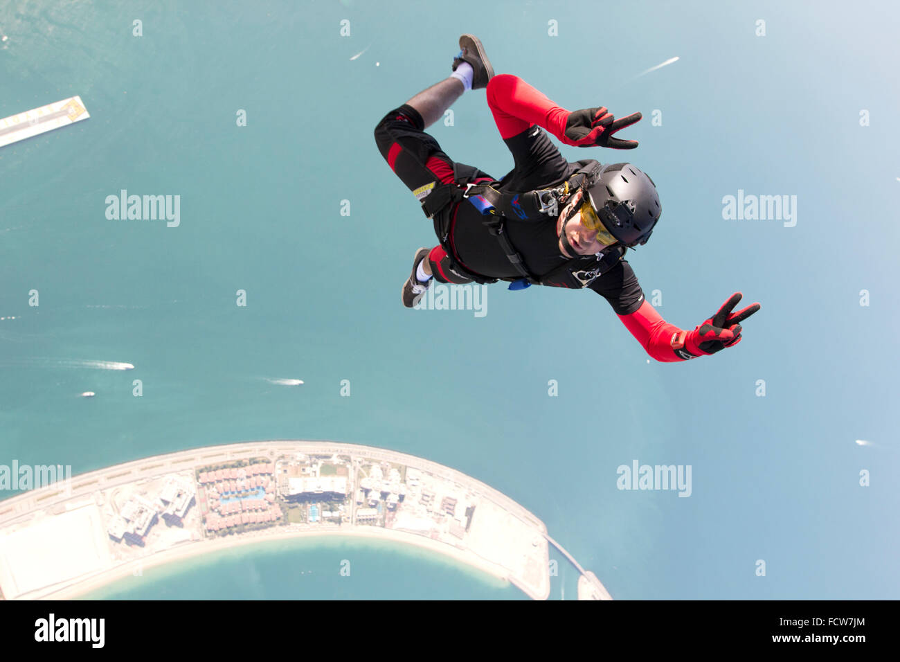Cet homme a sauté d'un avion sur la plage de Dubaï. Ressemble à ce qu'il jouit du saut en parachute d'après son doigt signes. Banque D'Images