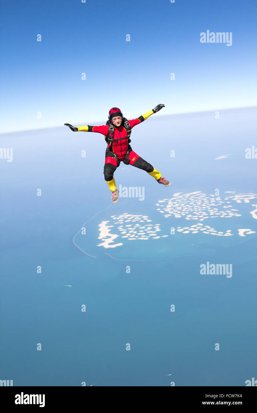 Parachutiste est sit-volant dans le ciel bleu sur la plage de Dubaï. Elle est ainsi profiter de la vue magnifique avec 120 km/h. Banque D'Images
