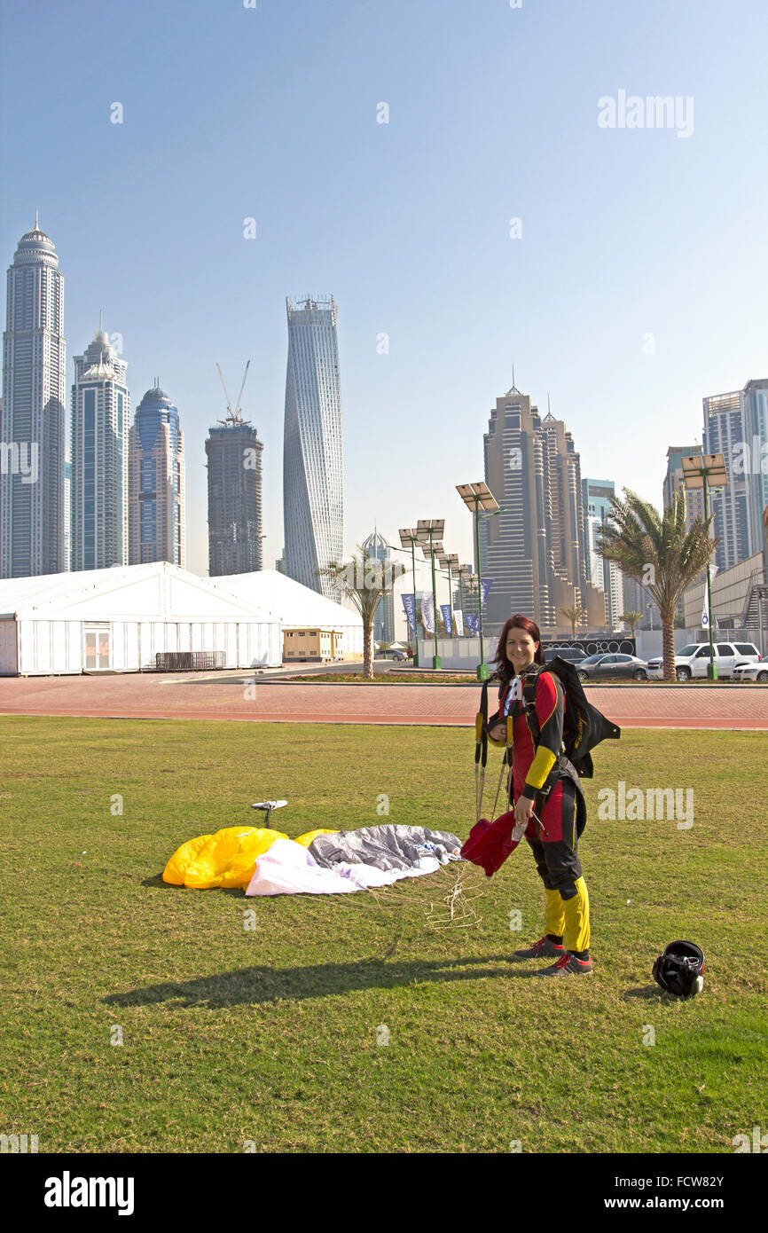 Cette fille parachutiste est très heureuse qu'elle a atterri sur le bouton Enregistrer de la zone d'herbe dédié sur l'aérodrome, après un saut sur Dubaï Palm. Banque D'Images