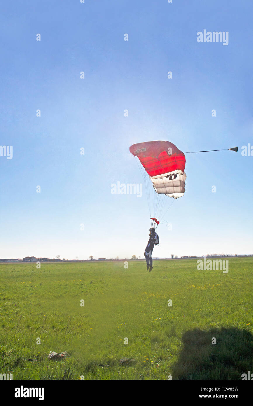 Ce parachutiste est volant sous le parachute dans l'approche finale de la zone d'atterrissage en herbe. Avec un ou deux pas elle va s'arrêter. Banque D'Images