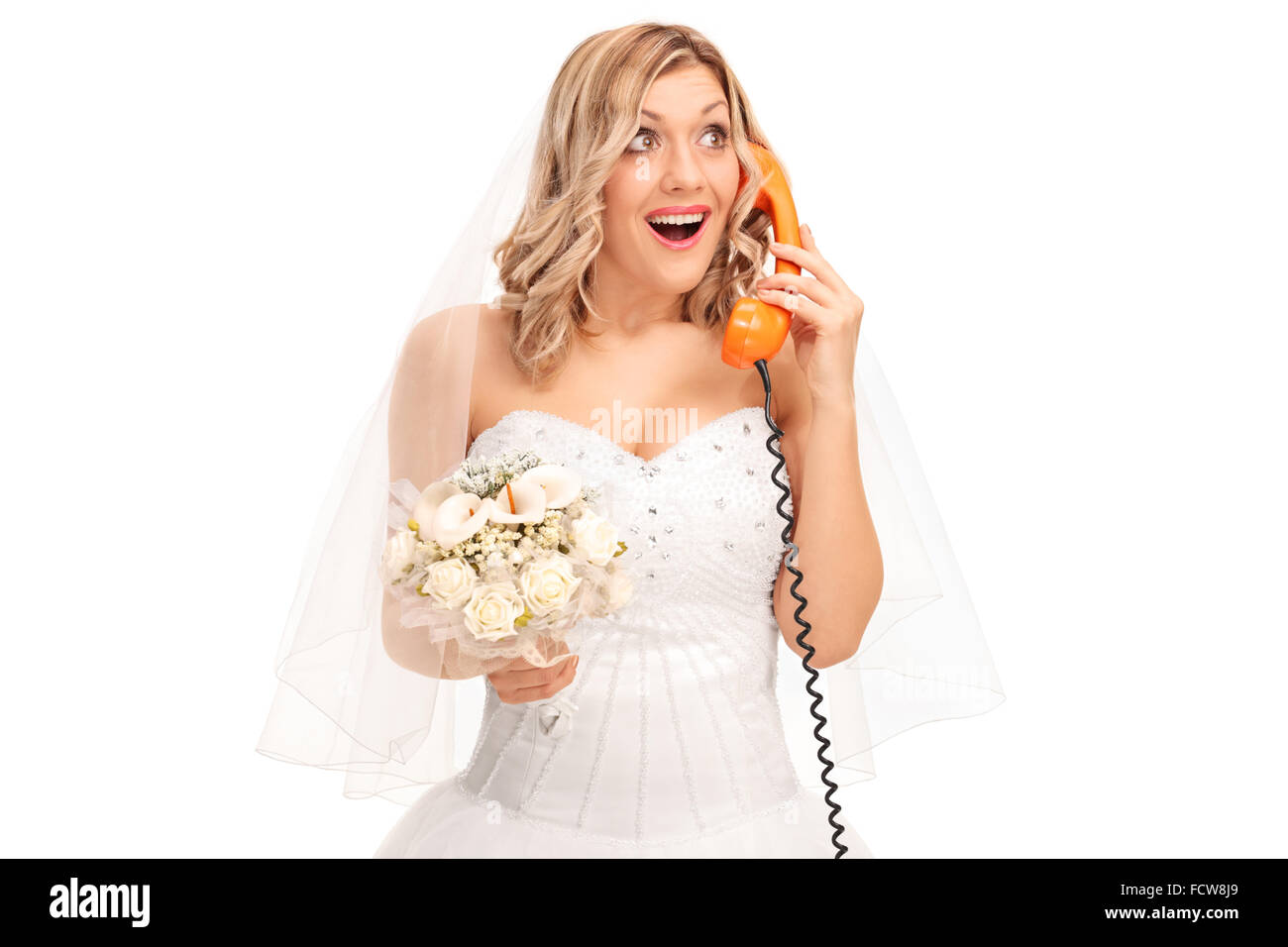 Cheerful bride holding a bouquet de mariage et de parler au téléphone isolé sur fond blanc Banque D'Images