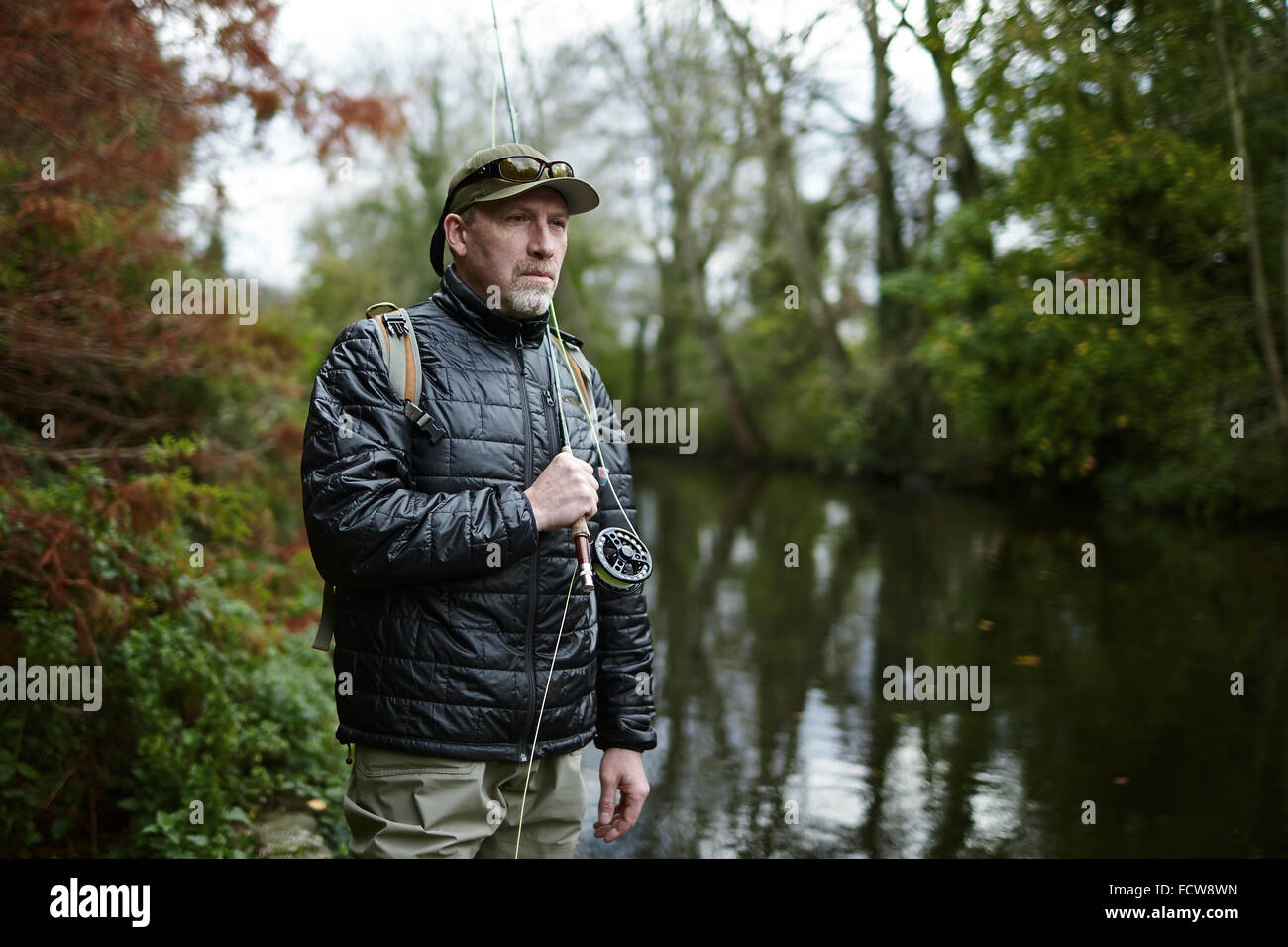 Un homme pêche à la mouche dans une rivière Banque D'Images