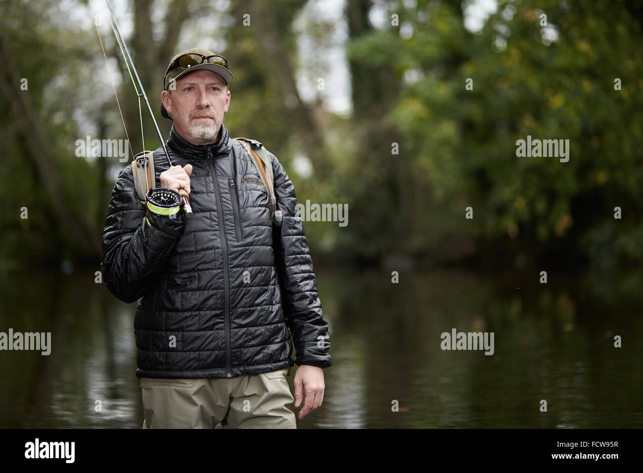 Un homme pêche à la mouche dans une rivière Banque D'Images