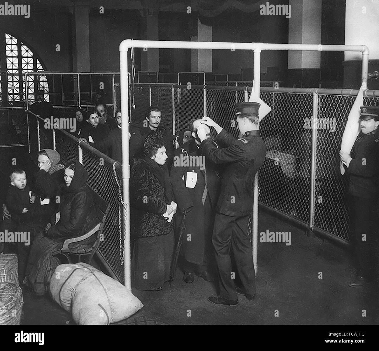 Les immigrants en cours d'examen par U S les inspecteurs à la station d'immigration, Ellis Island, New York, NY, c.1913 Banque D'Images